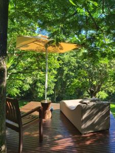 a patio with a table and an umbrella and a chair at LaPlek Guest Suite in East London