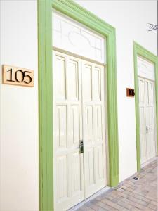 una puerta blanca con un adorno verde en un edificio en Hotel Boutique La Casona by Kavia en Mérida