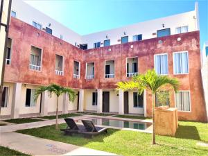 un edificio de apartamentos con piscina y palmeras en Hotel Boutique La Casona by Kavia en Mérida