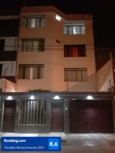 un edificio alto por la noche con un garaje en Tambo Huascar, en Lima