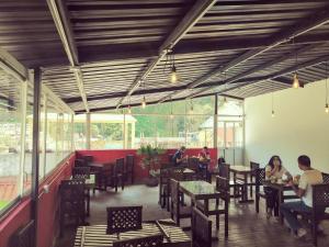 people sitting in a restaurant with tables and chairs at Hostal & Spa Casa Real in Baños