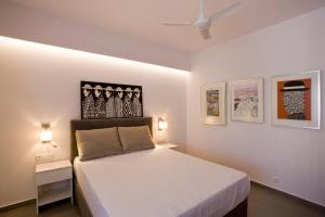 una camera con un letto e due comodini e due lampade di SYNATHENS APARTMENTS & STUDIOS ad Atene