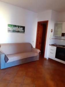 een woonkamer met een bank en een fornuis bij casa mirice in residence con piscina ,wifi,climatizzatore vicino al mare in Aglientu