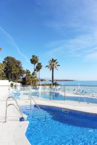 a swimming pool with a view of the ocean at VIP Dominion Beach Estepona in Estepona