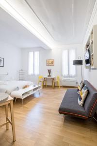 a white living room with a couch and a table at Canonica Suites in Bologna