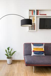 a living room with a blue couch and a lamp at Canonica Suites in Bologna