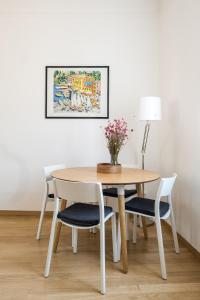 stół i krzesła z wazonem kwiatów w obiekcie Canonica Suites w Bolonii