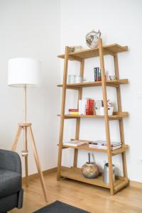 een houten boekenplank in een woonkamer met een lamp bij Canonica Suites in Bologna