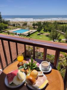 un tavolo con prodotti per la colazione e una vista sulla spiaggia di Ravena Cassino Hotel a Laguna