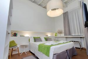 a white bedroom with a large bed and a table at B&G Navona Apartment in Rome