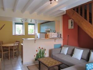 a living room with a couch and a kitchen at Gite Les Oyats in Cancale