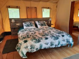 une chambre avec un lit dans une tente dans l'établissement Le lodge de La Boissière, à Andillac