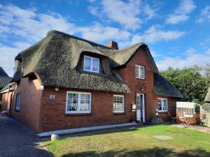 a thatch roofed house with a thatched roof at Haus Frisia Ferienwohnung Frisia 6 in Norddorf