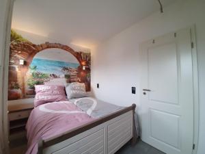 - une chambre avec un lit orné d'une peinture murale dans l'établissement Vier Jahreszeiten Haus 1 Whg 20, à Großenbrode