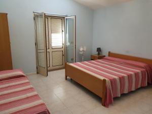カーポ・ヴァチカーノにあるLaura Casa Vacanzeのベッドルーム1室(ベッド1台、ガラスドア付)