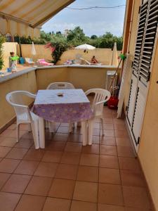 カーポ・ヴァチカーノにあるLaura Casa Vacanzeの家のバルコニーにテーブルと椅子