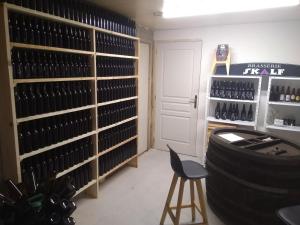 a wine tasting room with a stool and shelves of wine bottles at Les Gîtes du Château de Passillé in Parigné