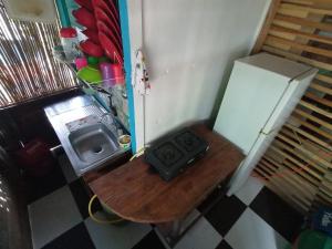 a small kitchen with a table and a refrigerator at Hospedaje Pirata Express in Capurganá
