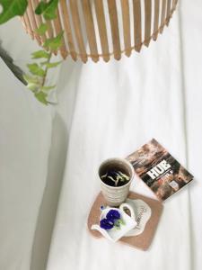 una mesa con un libro y una maceta de flores y una revista en VIỆT Hostel en Hue