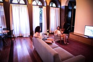 Dos mujeres sentadas en un sofá en una sala de estar en Villa 25 en Río de Janeiro