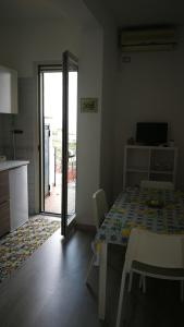 um quarto com uma mesa e uma cozinha com uma porta de vidro deslizante em La Marocella em Capri