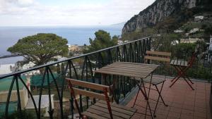 a table and chairs on a balcony overlooking the ocean at La Marocella in Capri