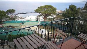 a balcony with chairs and a view of the water at La Marocella in Capri