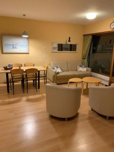 uma sala de estar com um sofá, uma mesa e cadeiras em Cosy Laguna Resort Knokke Duinbergen Furnitured Internet studio em Knokke-Heist