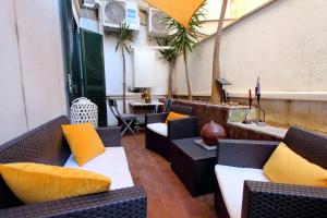 an outdoor patio with couches and tables and palm trees at B&G Navona Apartment in Rome