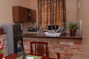 cocina con encimera de ladrillo y nevera en Kampala - Sleeps 4 - Apartment - Garden - Parking, en Bolingbroke