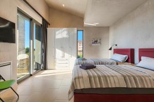 a bedroom with two beds and a tv and a balcony at Villen Matija & Mima in Fažana