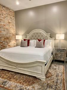 Cama blanca grande en habitación con pared de ladrillo en The Abita, en Nueva Orleans