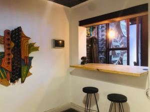 a bar with stools in a room with a window at Casa Palacio, Arte e Historia in Buenos Aires