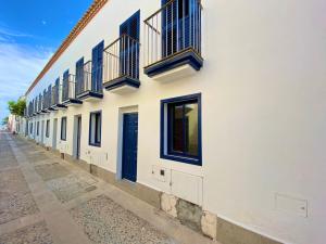 ein Gebäude mit blauen Türen und Fenstern auf einer Straße in der Unterkunft Apartamentos Vientos de Tabarca in Tabarca
