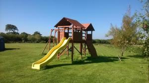 a playground with a slide in a field at Swallows Nest Stanbury Wharf in Holsworthy
