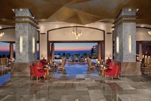 a lobby of a resort with red chairs and tables at Secrets Vallarta Bay Resort & SPA - Adults Only in Puerto Vallarta