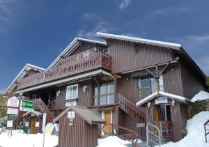 uma grande casa de madeira com neve em frente em Karelia Alpine Lodge em Falls Creek
