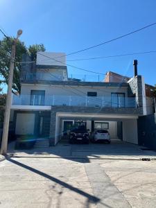 une maison avec deux voitures garées sur un parking dans l'établissement ALEM LANE, à Villa Carlos Paz