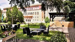 a park with chairs and a table and a building at Grand Hotel International - Czech Leading Hotels in Prague