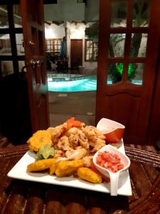 um prato de comida com camarão e mergulhos numa mesa em Weekendhostal em Montañita
