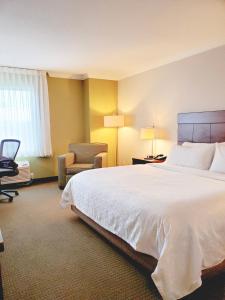 a hotel room with a large bed and a chair at Holiday Inn Express Hotel & Suites Portland-Northwest Downtown, an IHG Hotel in Portland