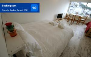 a bedroom with a white bed with towels on it at Departamento Céntrico con Vista in San Carlos de Bariloche