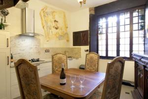 una cucina con tavolo in legno e bicchieri da vino di MAISON DE NOSTRADAMUS*** OCCITANIE INSOLITE ad Alet-les-Bains