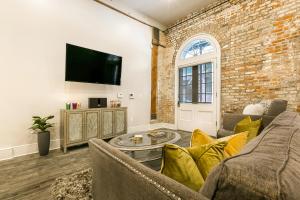 Una sala de estar con un sofá y una pared de ladrillos. en The Bordeaux, en Nueva Orleans