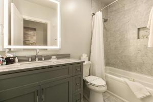 Un baño con lavabo, inodoro y espejo. en The Bordeaux, en Nueva Orleans