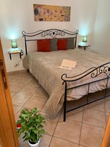 カステッルッツォにあるCasa Evaのランプ2つと植物が備わる部屋のベッド1台