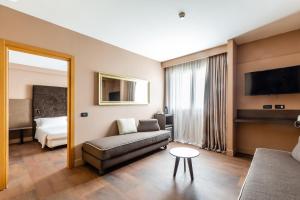 salon z kanapą, łóżkiem i lustrem w obiekcie Anusca Palace Hotel w mieście Castel San Pietro Terme