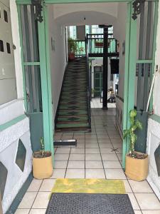 a hallway of a building with stairs and potted plants at Hostal Latina in Cuenca