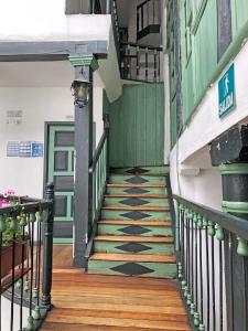 a stairway in a building with a green door at Hostal Latina in Cuenca