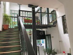 a spiral staircase in a building with plants at Hostal Latina in Cuenca